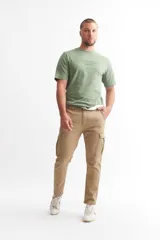Pantalón cargo color beige con bolsillos laterales con fuelle y cierre de botón a presión.