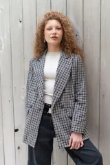 Blazer de paño con estampa a cuadros en tonos marrones y beige, de corte recto y mangas largas.