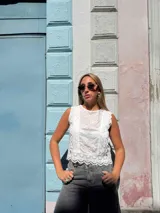 Musculosa blanca de broderie con detalles de encaje y botones en la espalda, sin mangas y corte corto.