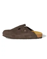 Zuecos de estilo mule marca Rivaro, confeccionados en cuero gamuzado color marrón moca. Presentan una tira ajustable con hebilla metálica grabada con el logo de la marca y una suela anatómica de corcho y látex.
