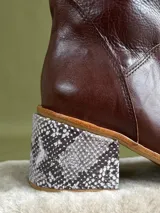 Botas de caña media de cuero marrón oscuro, con taco cuadrado forrado con estampado de serpiente y cierre lateral.
