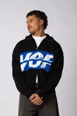 Campera de punto con cierre frontal completo, cuello polo y diseño de franja horizontal en color azul con letras blancas. Presenta puños y ruedo acanalados.