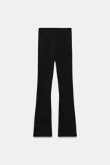 Pantalón de tiro medio con cintura elástica, confeccionado en tejido elástico con corte acampanado en el bajo.