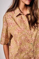 Vestido camisero corto con estampado tipo toile de Jouy a rayas, mangas cortas y cierre frontal con botones.