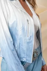 Chaqueta corta de cuero ecológico con diseño degradado de blanco a gris. Tiene cuello tipo solapa, cierre frontal asimétrico con broche y bolsillos con cierre.