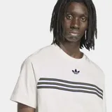Remera Adidas de corte clásico y cuello redondo, de color blanco. Presenta líneas horizontales oscuras y amarillas en el pecho y el logo del trébol bordado en azul marino.