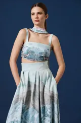 Falda larga de tiro alto con diseño estampado de paisaje montañoso y ciervos. Presenta una silueta amplia con tablas en la cintura y caída fluida.