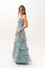 Vestido largo celeste con estampado abstracto en tonos marrones, escote halter con abertura en el frente y volados escalonados en la falda.