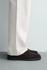 Mocasín casual de hombre con parte superior de piel con acabado serraje, diseño de corte liso con detalle de bordón, horma redonda y suela a tono.