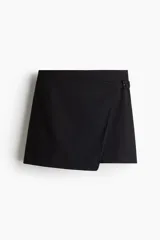 Short pollera de tiro alto negro con sutiles rayas verticales, diseño cruzado al frente y detalle de tira lateral con hebilla.