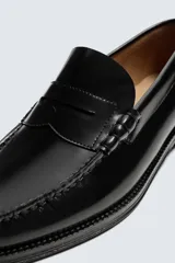 Mocasín de vestir fabricado en piel con acabado brillante, presenta detalle de antifaz en el empeine, plantilla de piel y suela a contraste con ligero tacón.