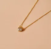 Gargantilla dorada con dije de corazón con circonia transparente.