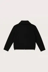 Abrigo de punto color negro, con cuello camisero, cierre frontal completo y dos bolsillos frontales tipo parche. Posee puños acanalados y diseño de corte recto.