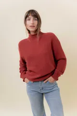 Polera de tejido de punto con textura marcada, cuello alto y diseño oversize con hombros caídos y terminaciones acanaladas.