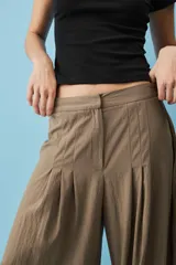 Pantalón marrón de corte ancho y fluido, con pinzas frontales y tiro alto.