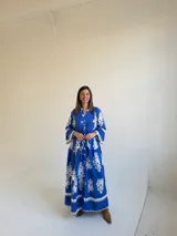 Vestido largo color azul con estampado ornamental en color blanco, escote en V con botones frontales y mangas tres cuartos con volados.