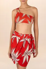 Minifalda pareo roja con estampado de flores blancas con lunares marrones, y ajuste con lazo lateral.