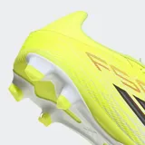 Championes de fútbol Adidas F50 Club, diseñados para terreno firme o múltiple. Presentan un diseño en color amarillo neón con detalles en blanco y negro, parte superior sintética Fiberskin con textura 3D para un mejor control del balón y tecnología SPRINTGRID.