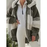 Campera peluda de mujer marca United Uy, con capucha y cierre frontal de cremallera. Presenta diseño de rayas horizontales en bloques de colores blanco, gris, beige y negro, con textura de piel sintética y puños elásticos.