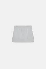 Falda corta gris melange de tiro medio con cintura elástica, confeccionada en hilatura con mezcla de algodón. Cuenta con forro interior tipo shorts del mismo tejido.