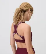 Top deportivo Get Over confeccionado en microfibra bordó, con diseño estilo nadador, breteles anchos y ribetes contrastantes en tono crudo en el escote, sisas y bajo busto.