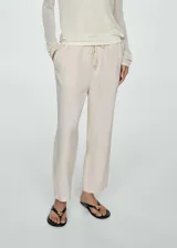 Pantalón de lino color beige, de corte recto y diseño relaxed con cintura elástica y cordón ajustable.