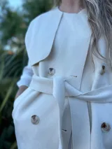 Chaleco color beige con cuello solapa, doble botonadura y lazo para atar en la cintura.