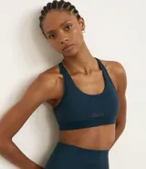 Top deportivo color azul oscuro, con diseño nadador en la espalda, copas removibles y recortes estratégicos de tela respirable en el frente. Confeccionado en microfibra ligera y elástica, ofrece sujeción moderada.