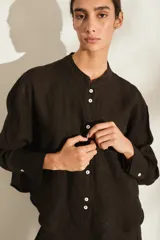Camisa de lino italiano color beige, de corte holgado, con cuello mao, manga larga y bolsillo aplicado en el pecho.