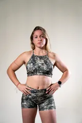 Top deportivo con estampado de camuflaje en tonos verde, gris y blanco. Tiene tirantes finos y logo de la marca en el frente.