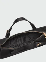 Cartera de hombro pequeña de diseño minimalista y estructura alargada, con correa ajustable y cierre superior.