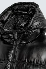 Campera puffer negra con capucha, cierre frontal con cremallera, bolsillos laterales con cremallera y puños elásticos.