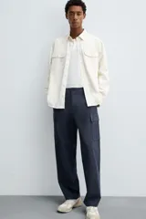 Pantalón cargo de corte regular fit, confeccionado en tejido ligero de algodón. Presenta bolsillos laterales tipo cargo con solapa, bolsillos frontales y bolsillos traseros de vivo. Cierre frontal con cremallera y botón.