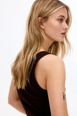 Musculosa entallada de tejido de punto de algodón acanalado en color marrón oscuro, con escote redondo y diseño básico sin mangas.