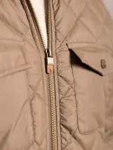 Campera acolchada azul marino con cuello de pana, cierre frontal con cremallera y bolsillos con solapa en el pecho.