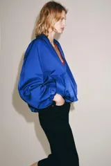 Chaqueta bomber de Zara Woman Collection color azul, con escote en pico, manga larga abullonada con puños elásticos, bolsillos delanteros y cierre frontal cruzado.