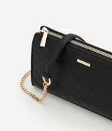 Cartera bandolera pequeña de poliuretano color negro con diseño acolchado geométrico. Cuenta con cierre superior metálico y asa de cadena dorada.