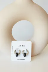 Aros de argolla en acero quirúrgico con dije de piedra natural en tono azul.