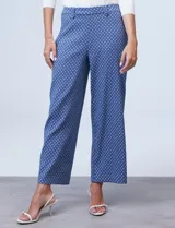 Pantalón de pierna amplia marca Zac & Rachel, confeccionado en tejido elastizado azul con estampado floral. Presenta bolsillos inclinados en la parte delantera, bolsillos simulados en la parte trasera, pretina con pasadores y botones.