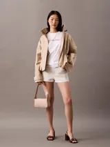 Remera blanca de manga corta con cuello redondo y corte regular. Presenta el logo de Calvin Klein estampado en el pecho con un efecto degradado de colores que va del rosado al cobre.