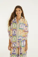Camisa de algodón con diseño estampado de sellos vintage de bananas en varios colores, cuello camisero clásico y mangas largas.