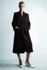 Abrigo oversize de Zara Woman Collection confeccionado en hilatura con lana. Presenta cuello con solapa de muescas, manga larga, bolsillos con solapa en el delantero y cierre frontal cruzado con botones.