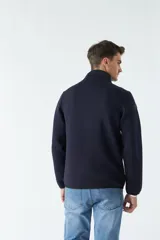 Campera azul marino con cuello alto y bolsillos laterales con cierre.