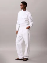 Buzo con capucha Calvin Klein de corte cropped, confeccionado en tejido de algodón y poliéster. Presenta un diseño minimalista en color blanco con el logotipo de la marca bordado en pequeño en el pecho y cordones ajustables en la capucha.