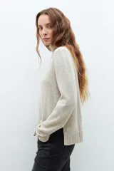 Sweater beige melange de cuello alto, tejido de punto liso y corte clásico.