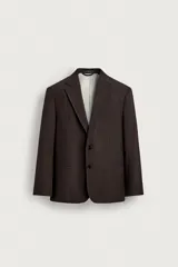 Blazer de corte relaxed fit color marrón, confeccionada en tejido con mezcla de lana. Presenta cuello con solapas de muesca, manga larga, bolsillos de vivo en la cadera y cierre frontal de botonadura con dos botones. Cuenta con forro interior combinado a contraste y abertura en el centro de la espalda.