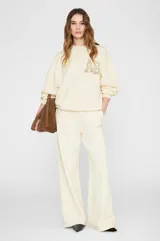 Pantalón jogger blanco de tiro alto y silueta amplia wide leg, con elástico en la cintura y sutil bordado en el lateral.