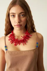 Vestido corto de corte recto y holgado, color camel, con breteles finos decorados con cuentas de colores en los extremos. Cuenta con bolsillos laterales.