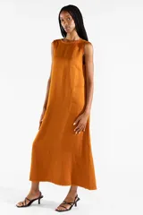 Vestido largo sin mangas de color mostaza, de corte recto y holgado, con escote redondo y bolsillos laterales. Confeccionado en mezcla de lyocell, viscosa y lino.