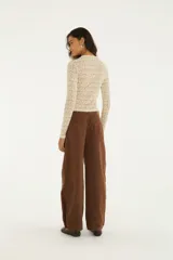 Pantalón de jean marrón de tiro alto y calce amplio, con bordados florales en contraste a lo largo de las piernas y bolsillos funcionales.